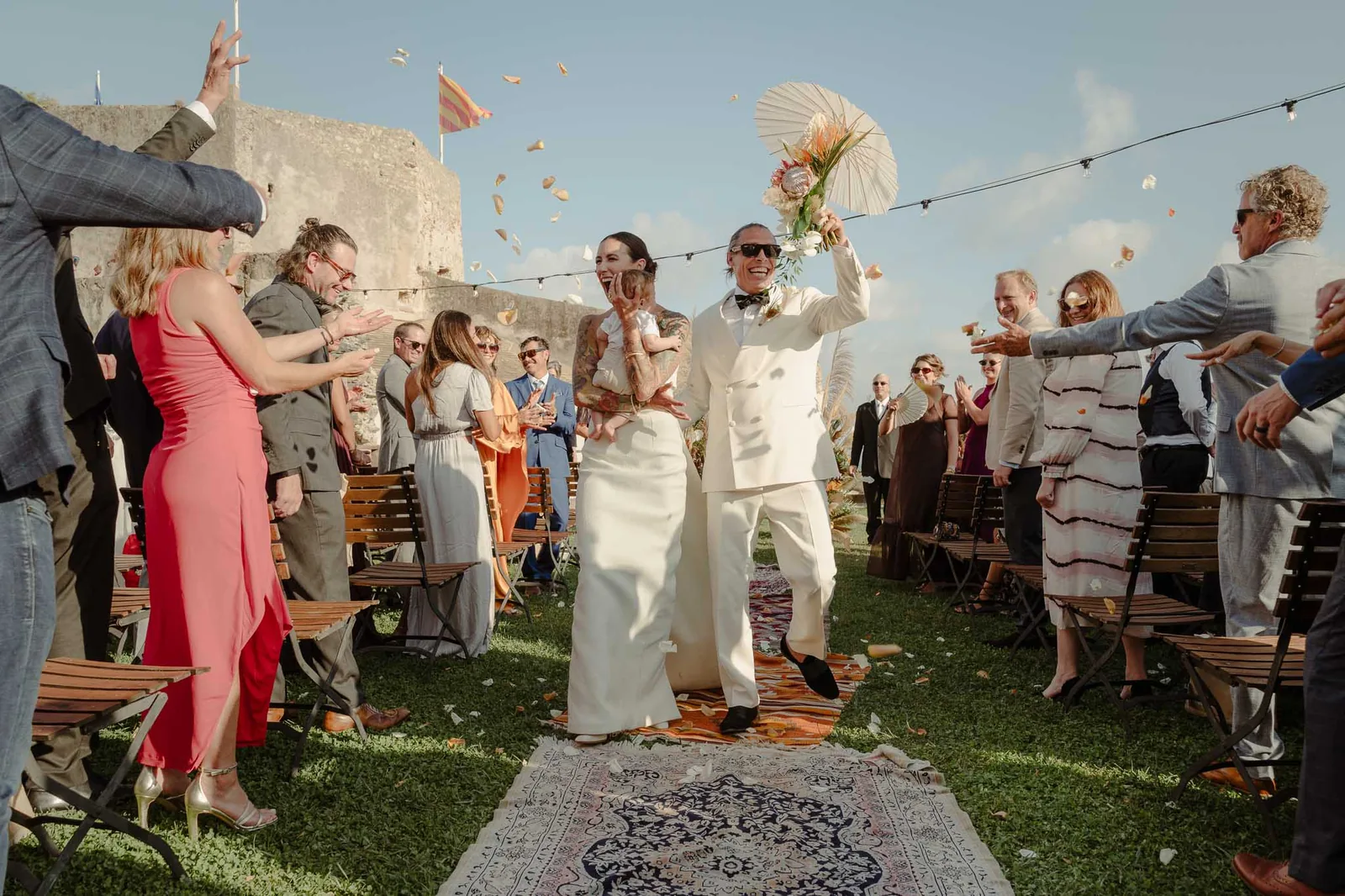 Gli sposi escono dalla cerimonia tra i petali lanciati dagli invitati