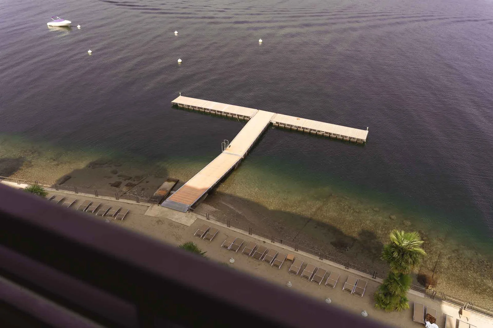 Dall'alto, il pontile bianco sul Lago Maggiore davanti all'albergo