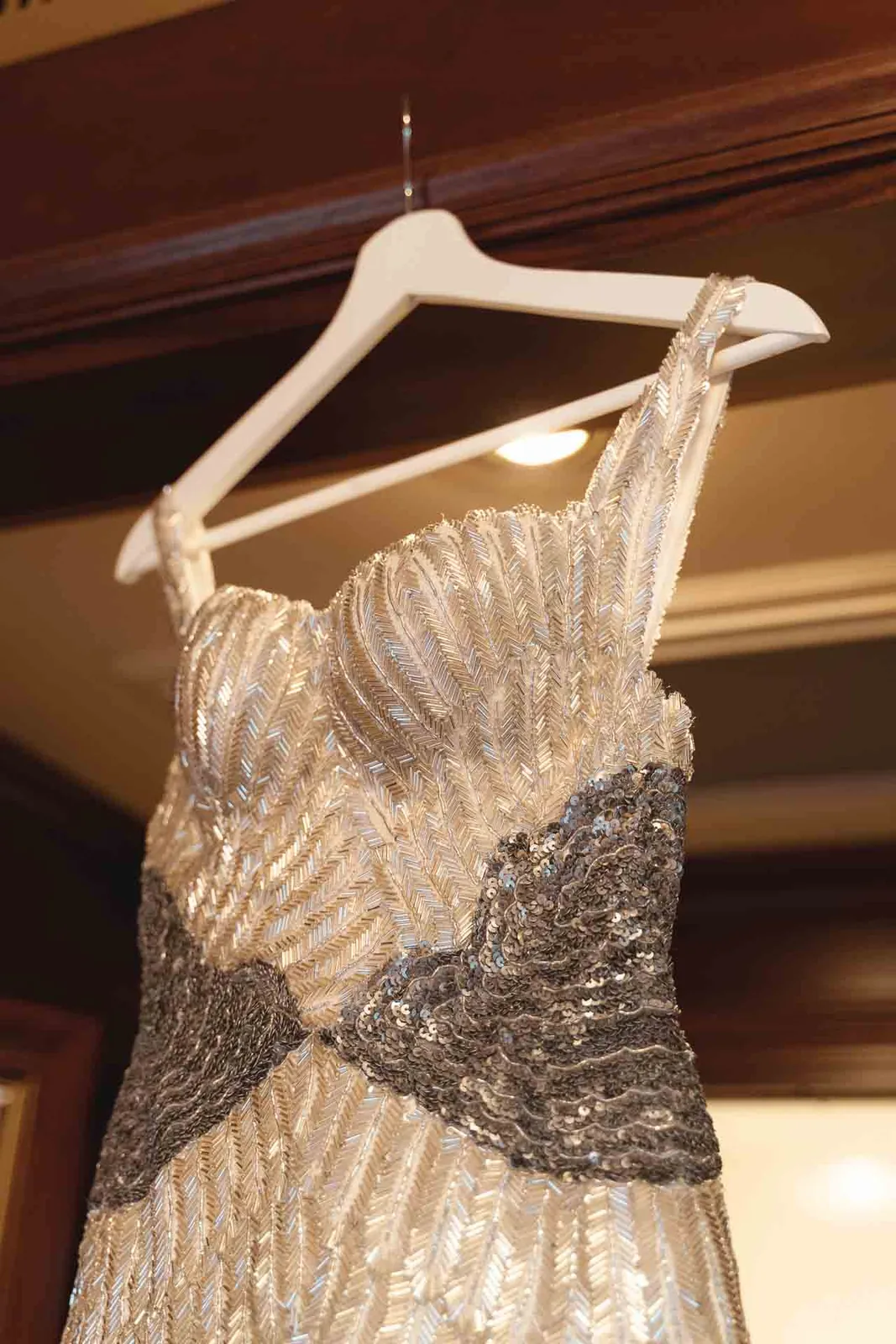L'abito da sposa appeso, visto dal basso, con le perline argento