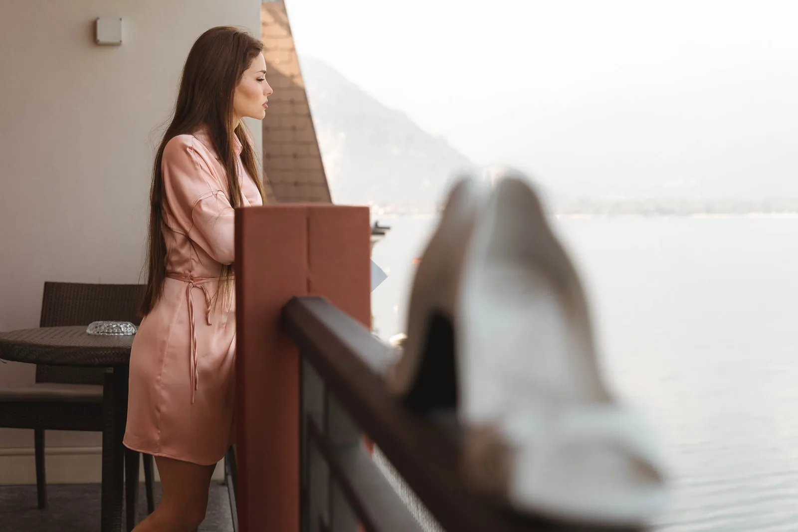 La sposa sul balcone affacciato sul lago, con le scarpe in primo piano