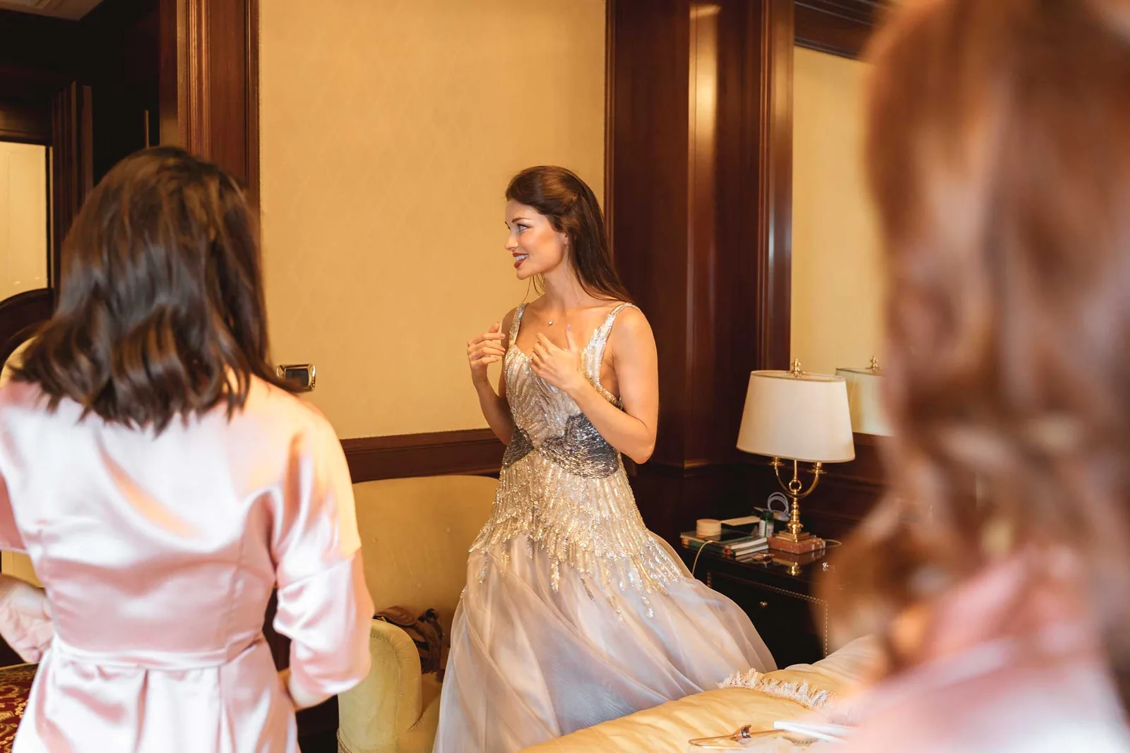 La sposa nell'abito da sposa, vista tra le amiche in vestaglia