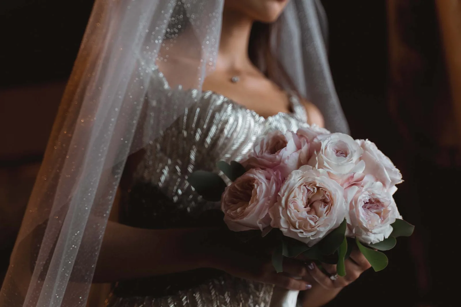 Il bouquet di rose rosa e le perline dell'abito, sotto il velo