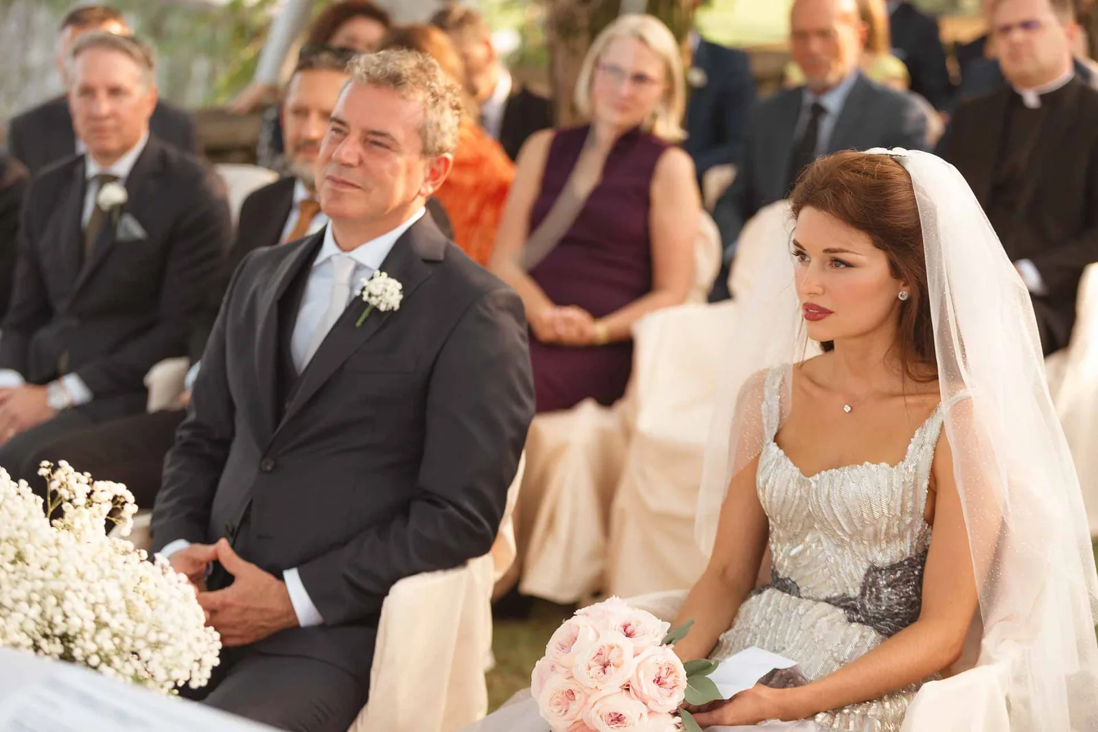 Gli sposi seduti alla cerimonia, tra gli invitati