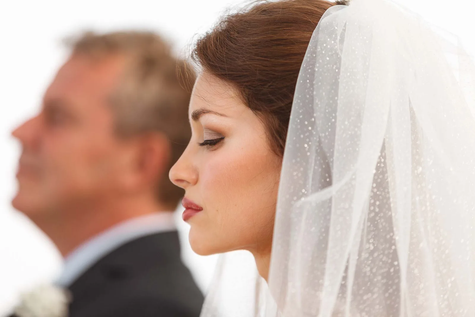 Il profilo della sposa con il velo, accanto allo sposo