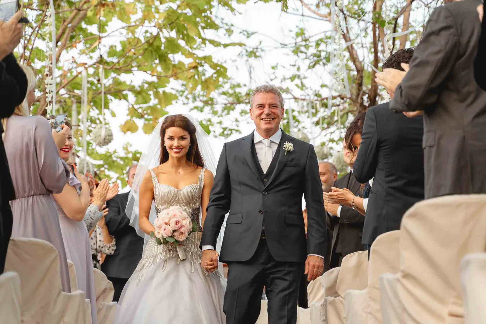 Gli sposi escono dalla cerimonia mano nella mano tra gli invitati