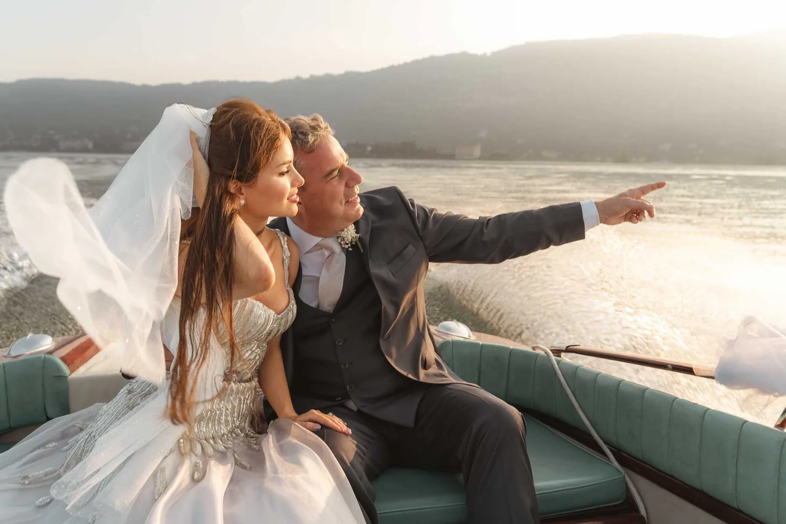 Lo sposo indica la riva alla sposa, sul motoscafo
