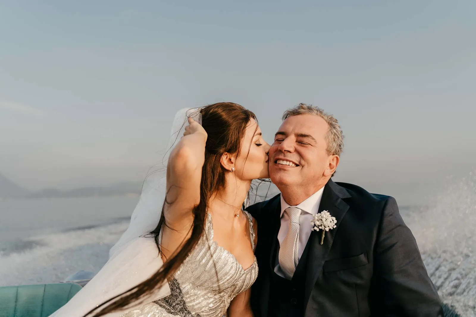La sposa bacia lo sposo sulla guancia, sul motoscafo