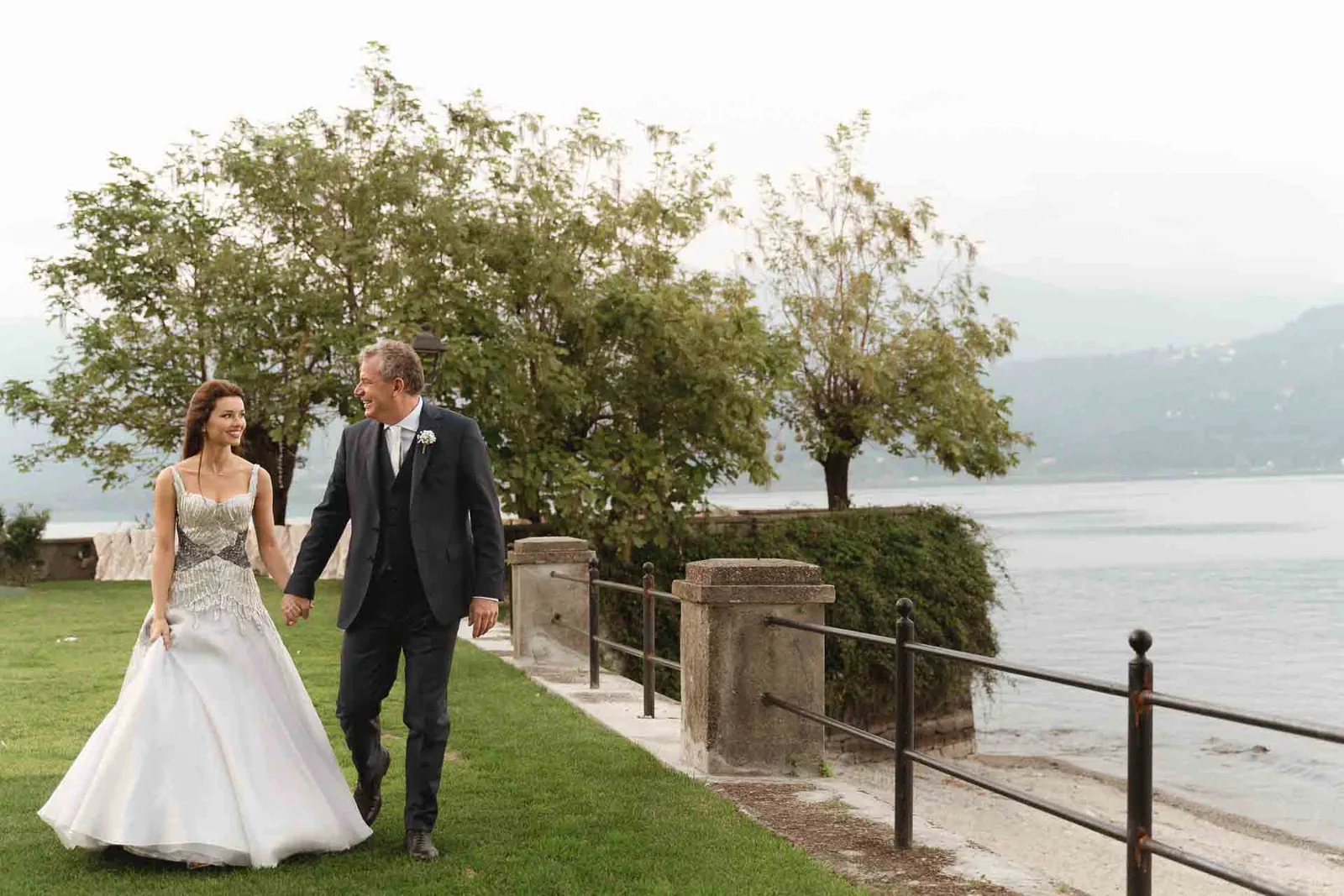 Gli sposi passeggiano mano nella mano lungo la riva del Lago Maggiore, a Baveno