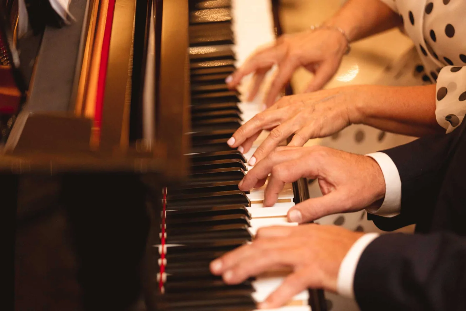 Mani a quattro sul pianoforte durante la cena