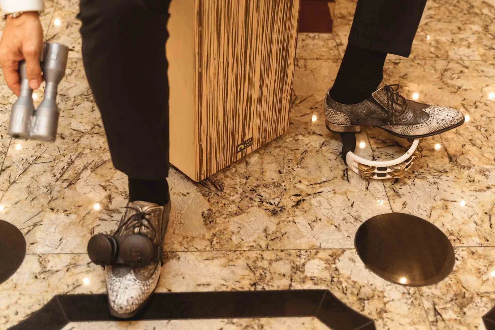 Le scarpe argentate di un musicista accanto a un tamburello