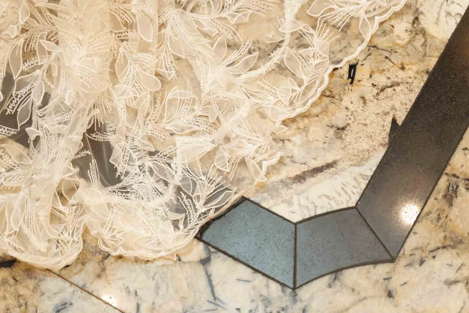 Il pizzo dell'abito della sposa sul pavimento di marmo