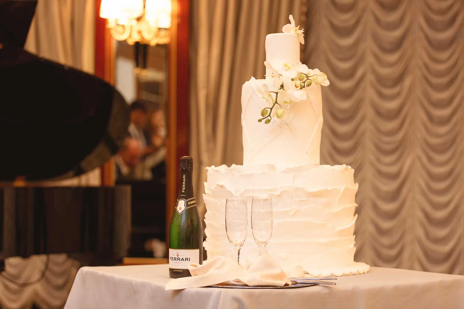 La torta nuziale bianca, con lo spumante e due calici