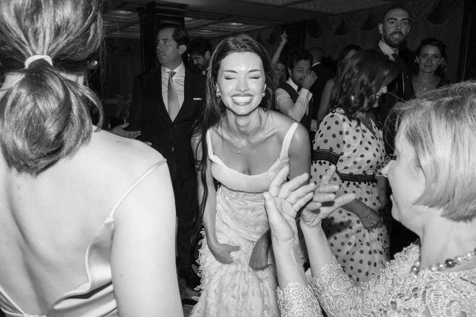 In bianco e nero, la sposa ride tra le amiche sulla pista