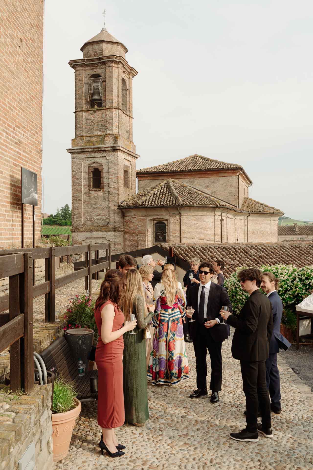 Gli invitati all'aperitivo nella piazzetta, sotto il campanile della chiesa di Barbaresco