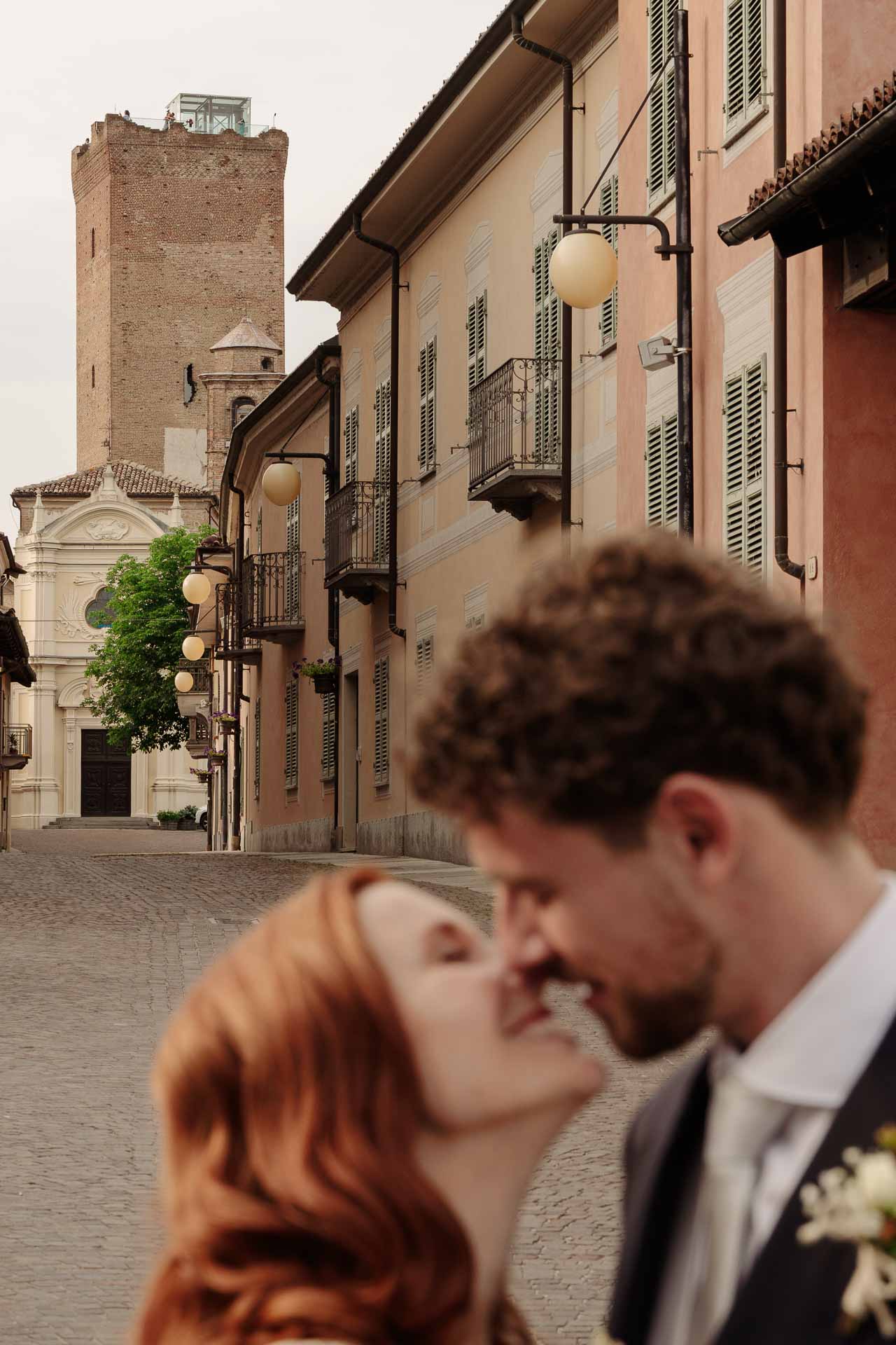 Il bacio degli sposi nella via di Barbaresco, con la torre in fondo
