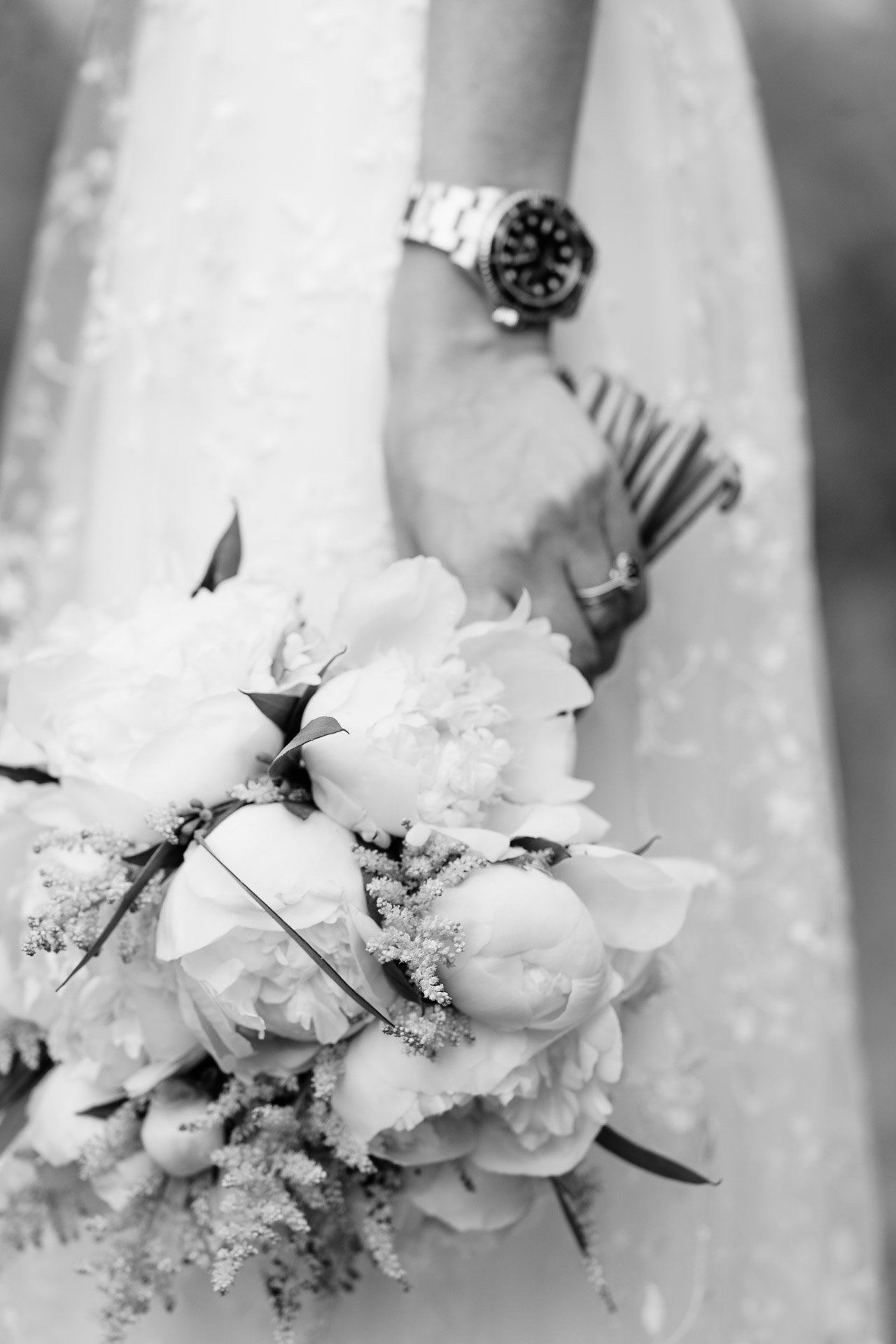 In bianco e nero, il bouquet di peonie bianche nella mano della sposa