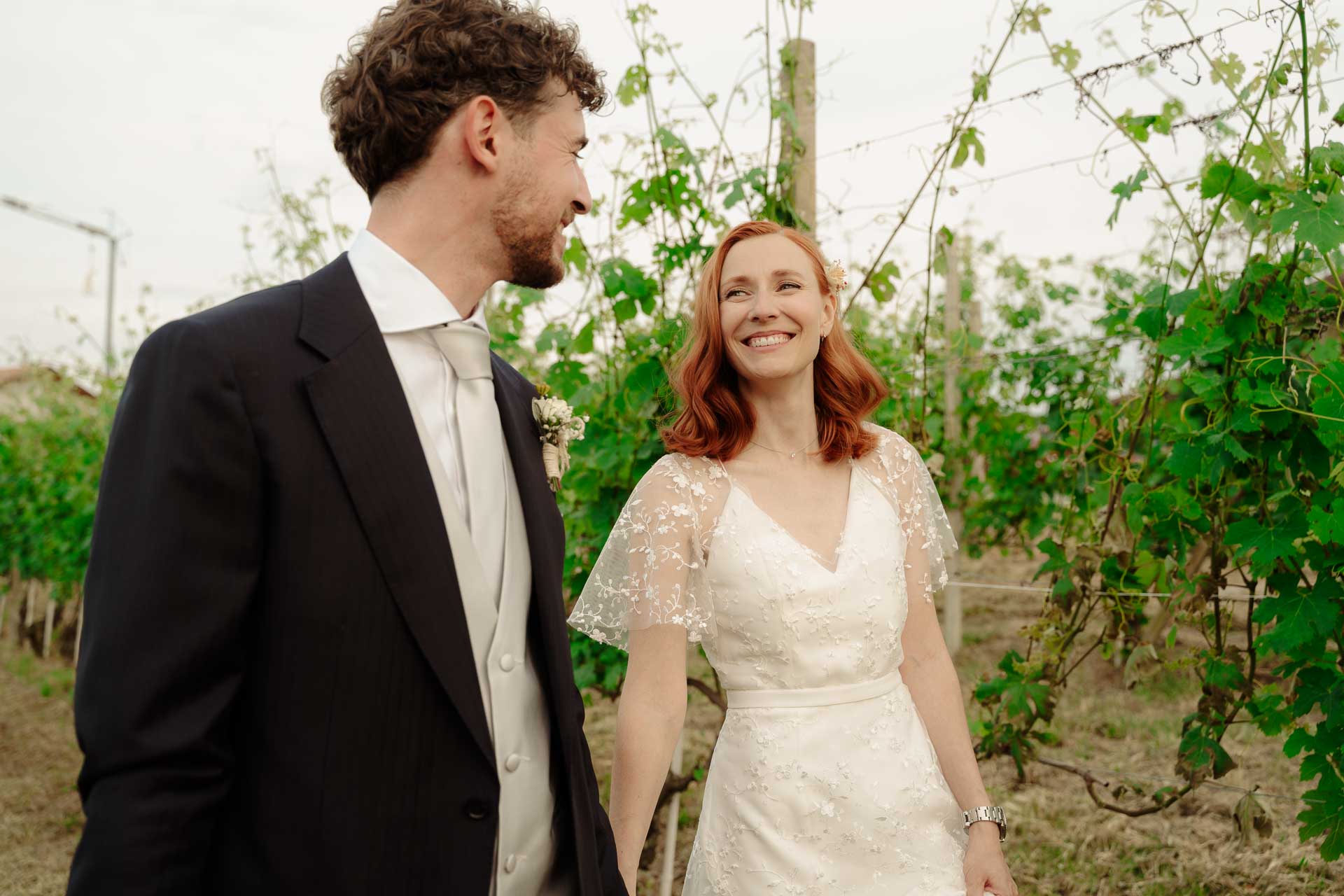 Lo sposo guarda la sposa che sorride, tra le vigne