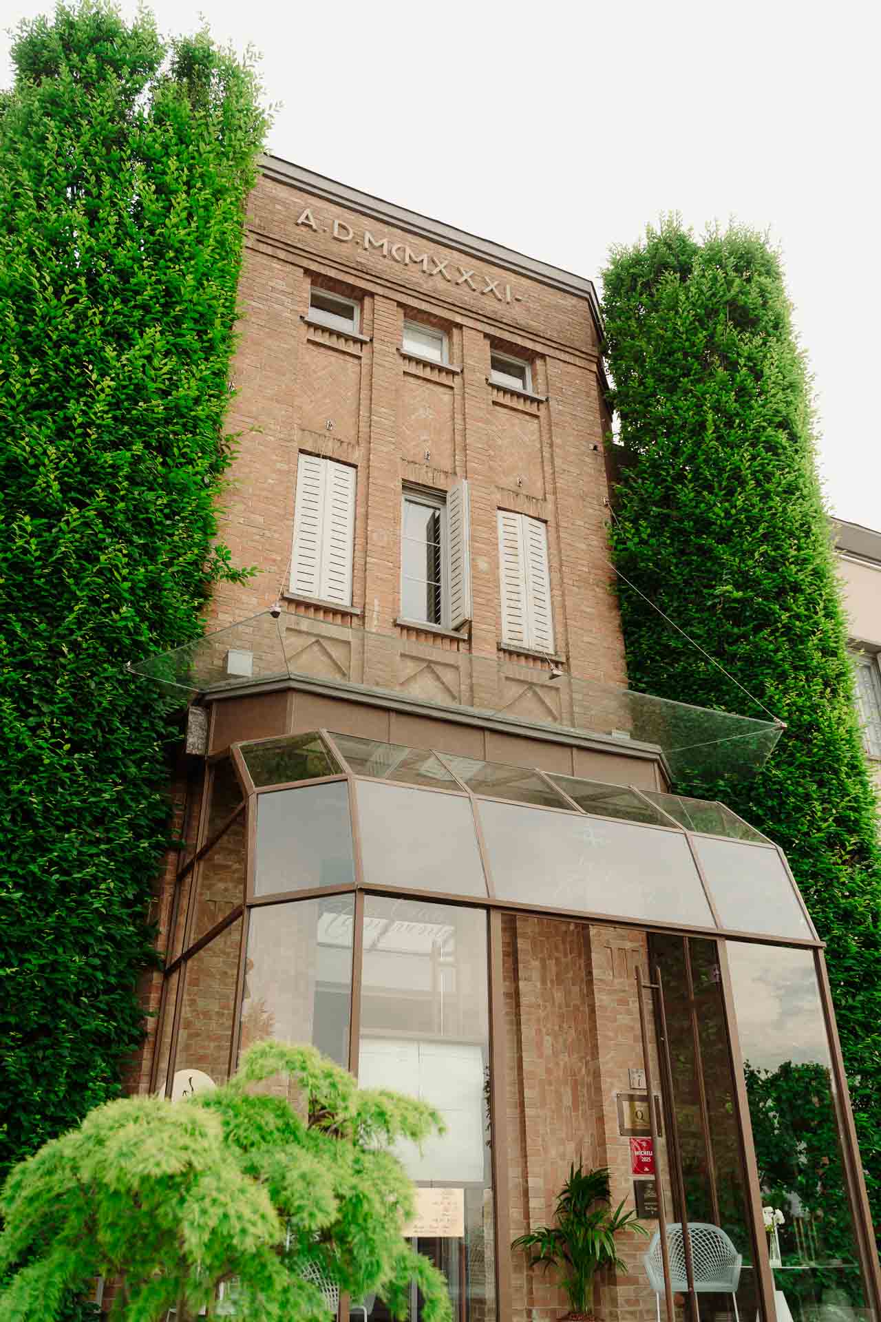 La facciata in mattoni del 1931 della Ciau del Tornavento, a Treiso, tra i cipressi