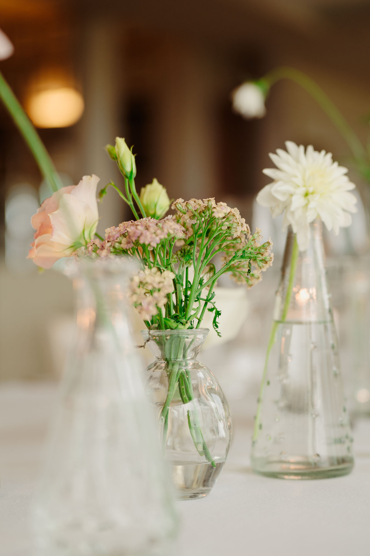 I fiori nelle caraffe di vetro, sulla tavola apparecchiata
