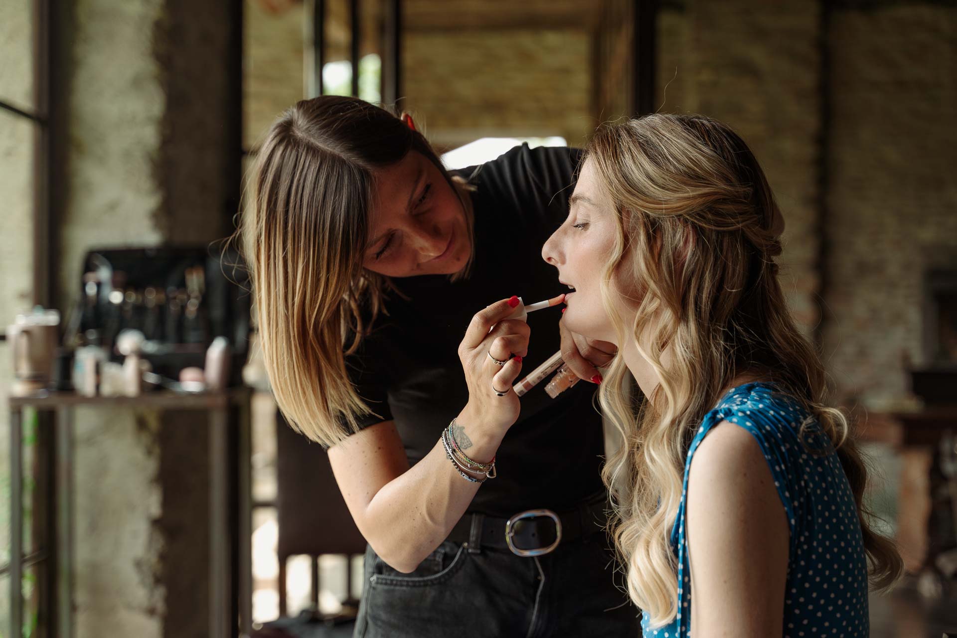 La truccatrice passa il rossetto a un'amica bionda
