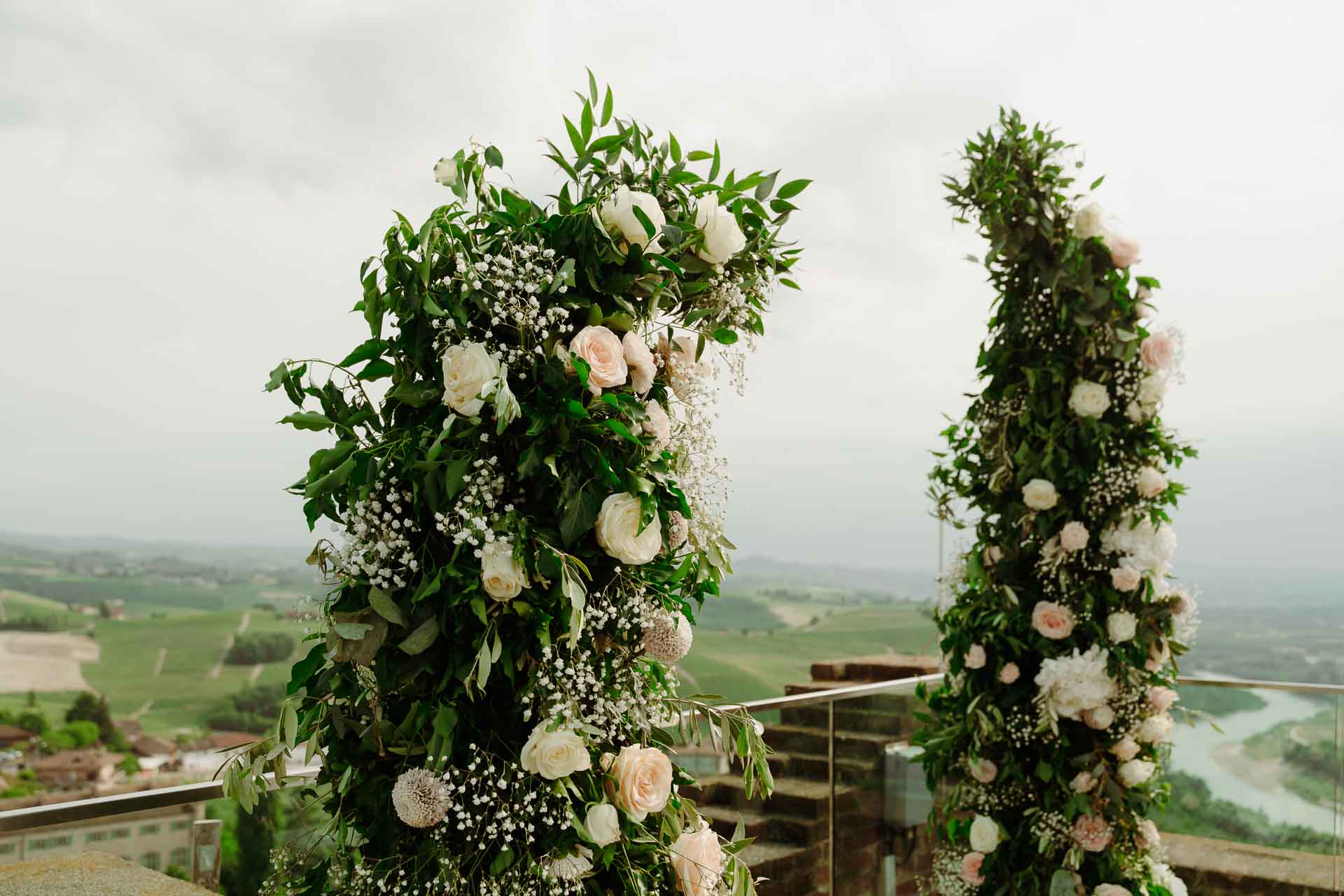 I due archi di rose bianche sulla terrazza della torre, con le colline e il Tanaro sullo sfondo