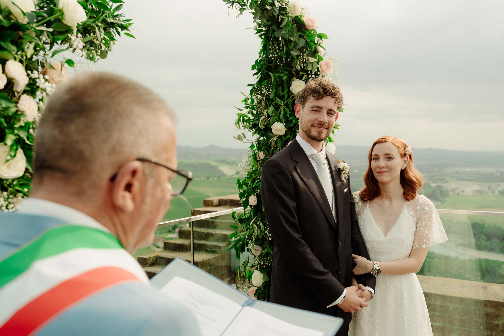 L'ufficiale con la fascia tricolore legge il rito davanti agli sposi