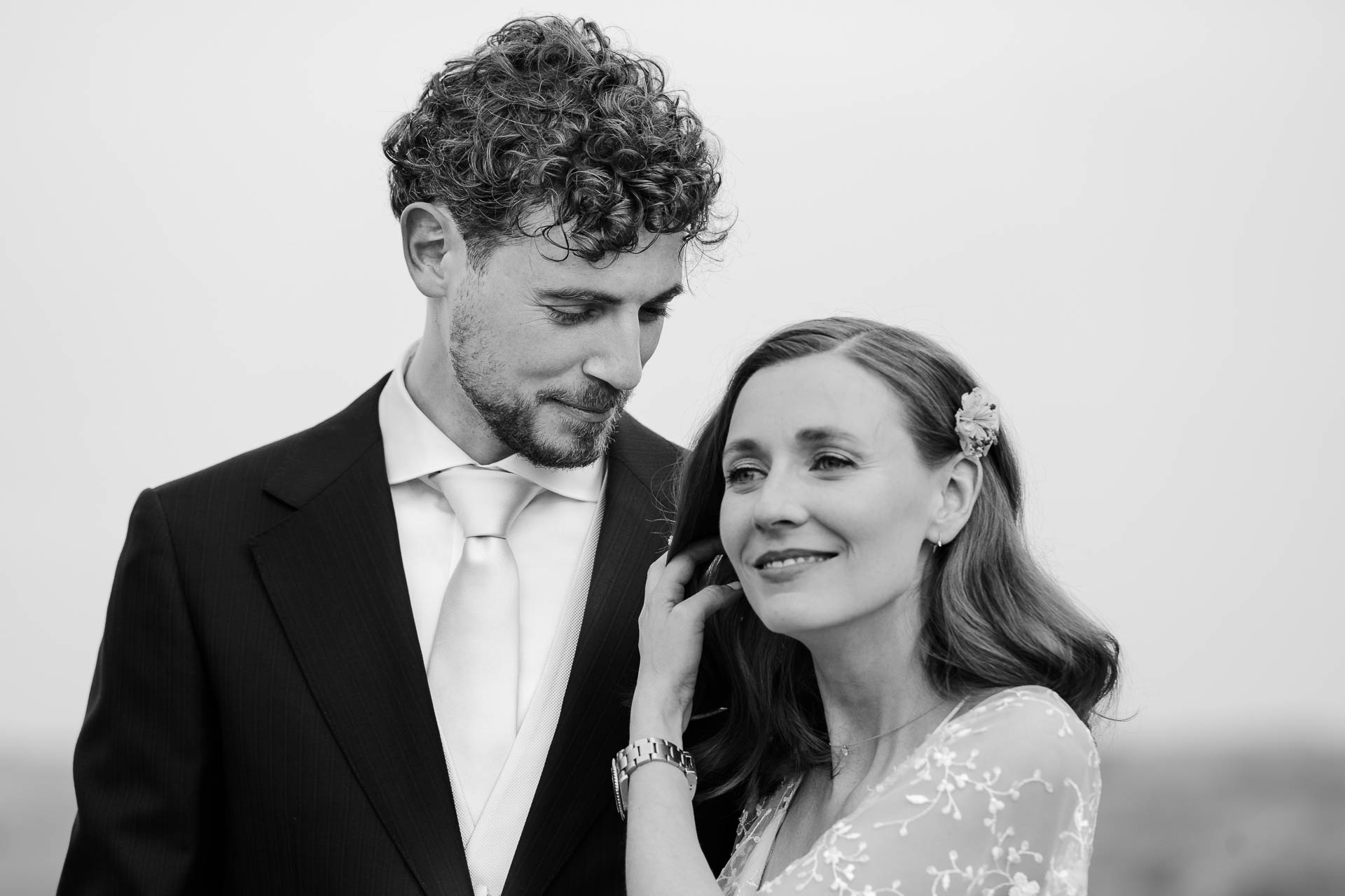 In bianco e nero, la sposa sorride appoggiata allo sposo, che la guarda