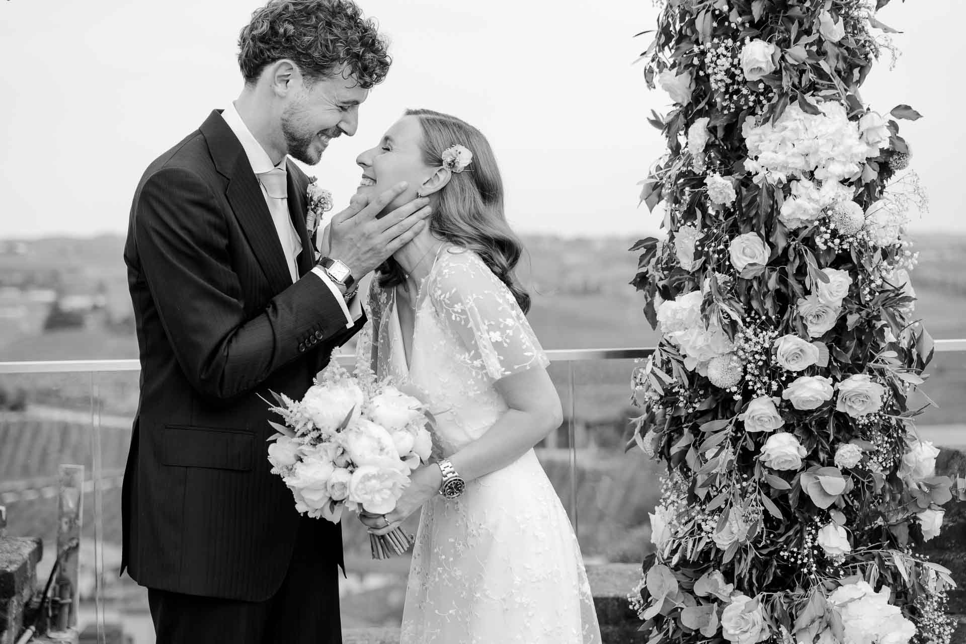 In bianco e nero, la sposa prende il viso dello sposo tra le mani