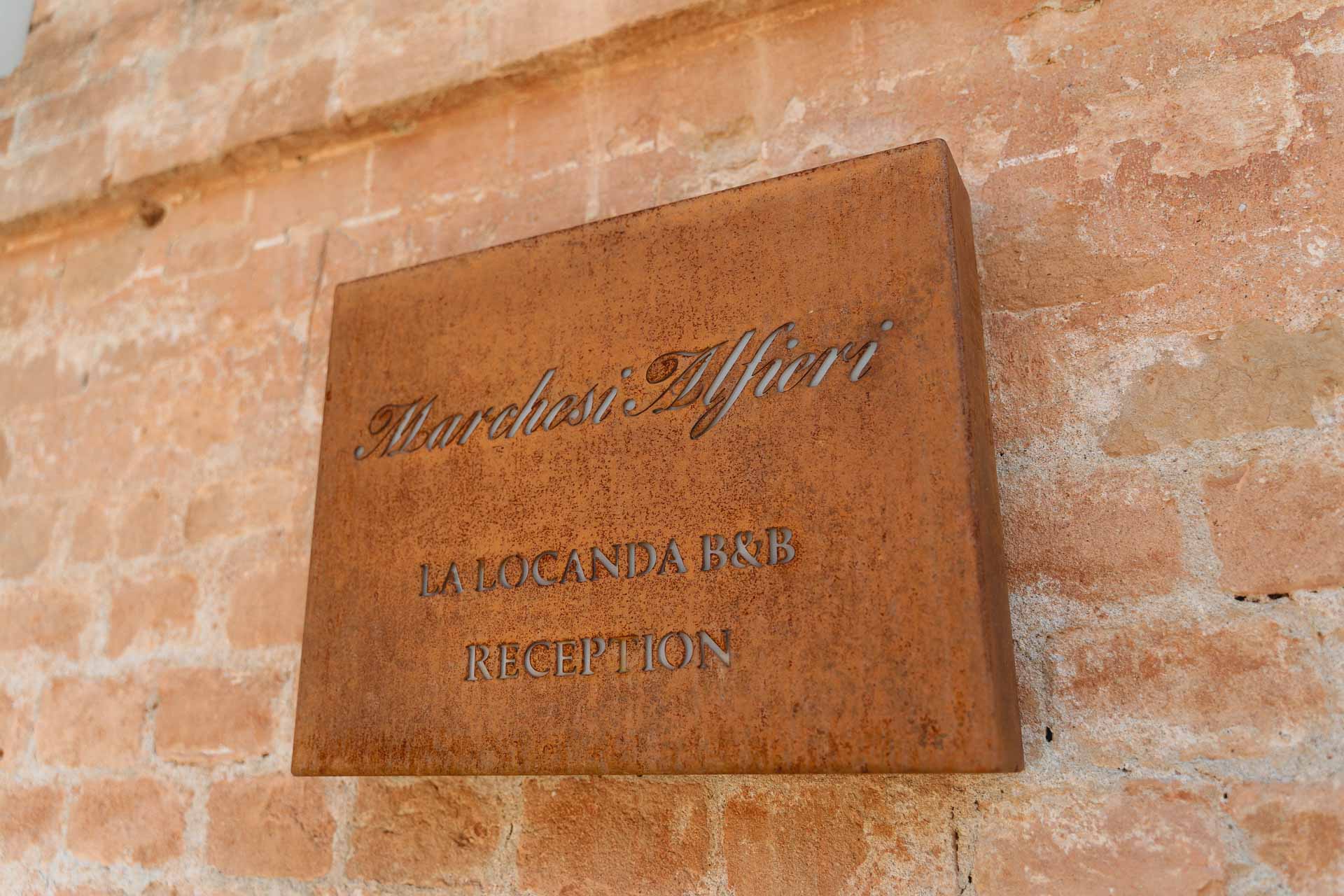 L'insegna della locanda della Tenuta Marchesi Alfieri sul muro di mattoni