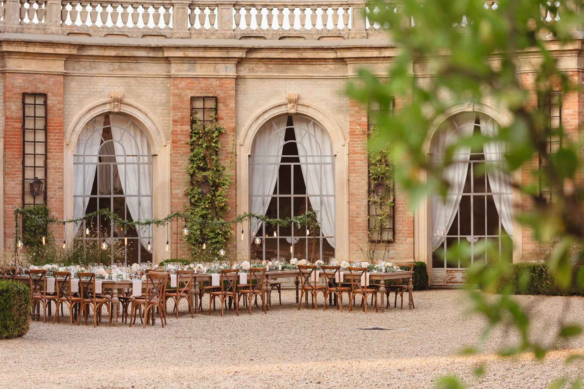 La corte ad arcate della tenuta vista tra le foglie