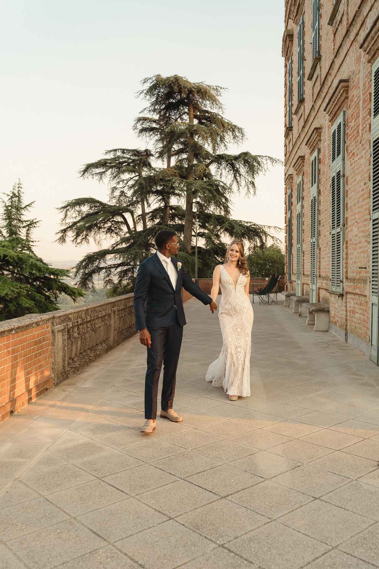 Gli sposi camminano sulla terrazza della Tenuta Marchesi Alfieri al tramonto