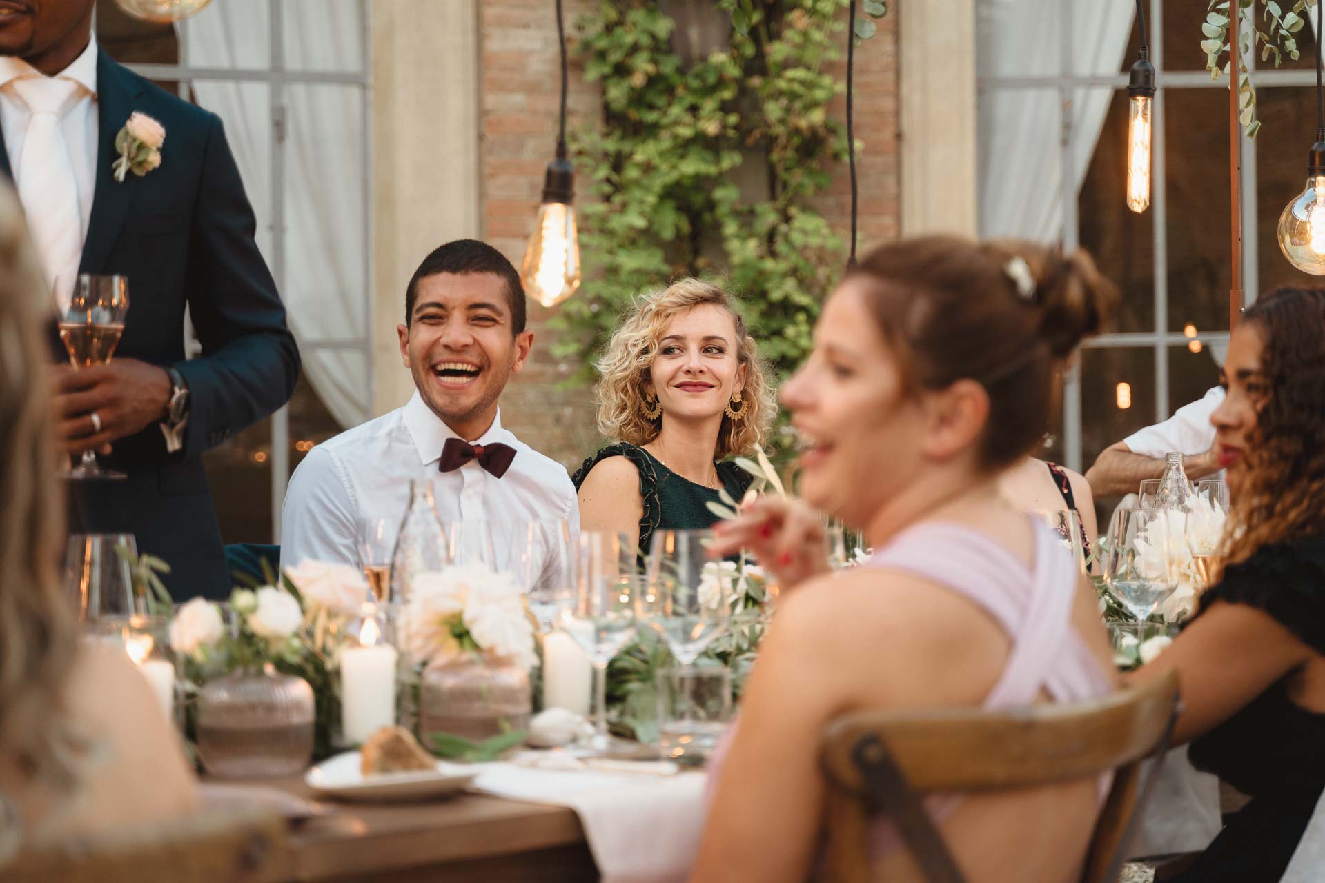 Gli amici ridono a tavola durante la cena