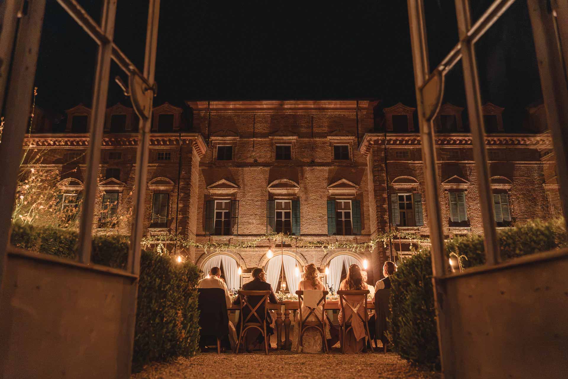 La Tenuta Marchesi Alfieri illuminata di notte, vista oltre un cancello