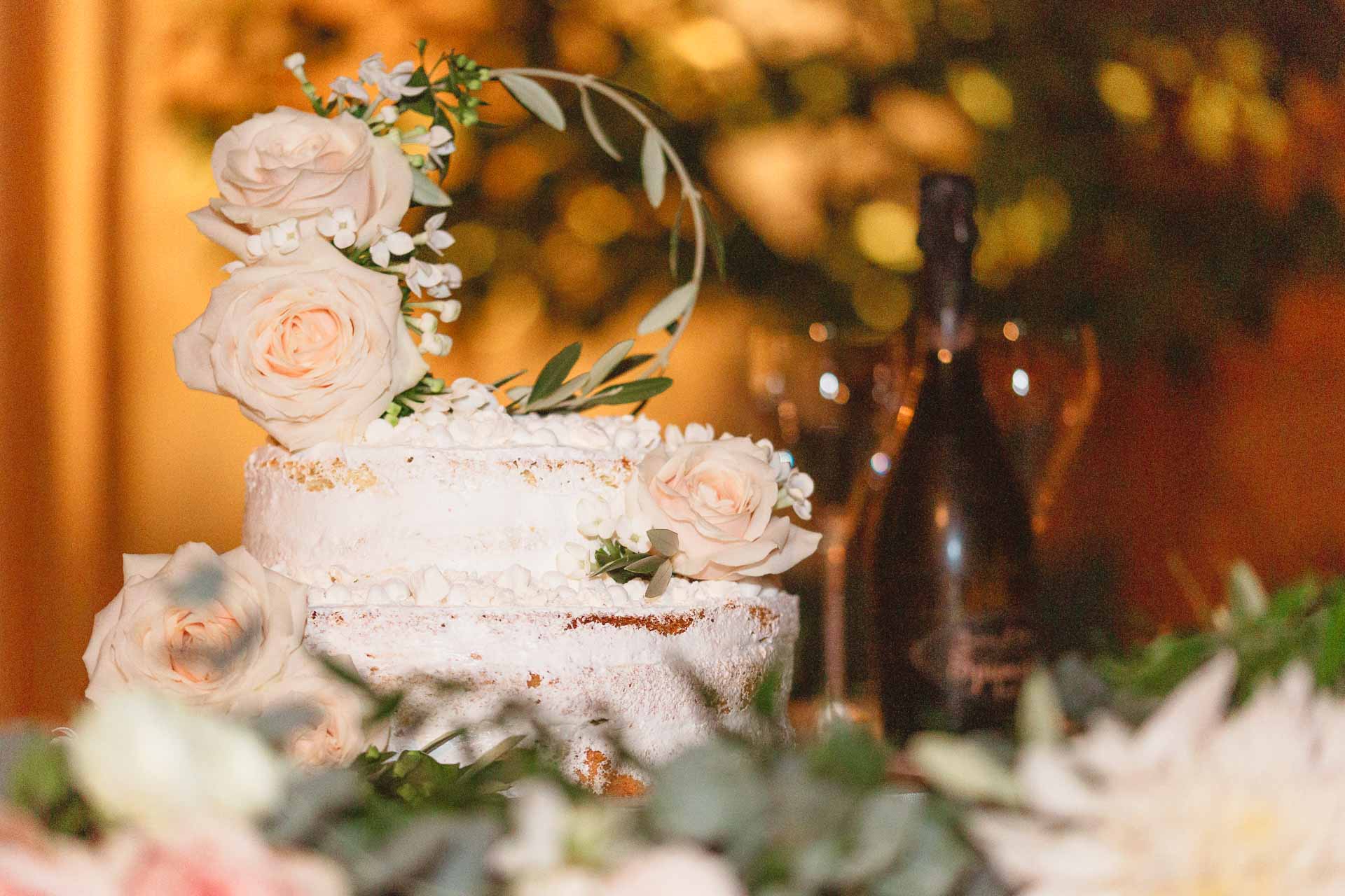La torta nuziale con le rose, accanto allo spumante