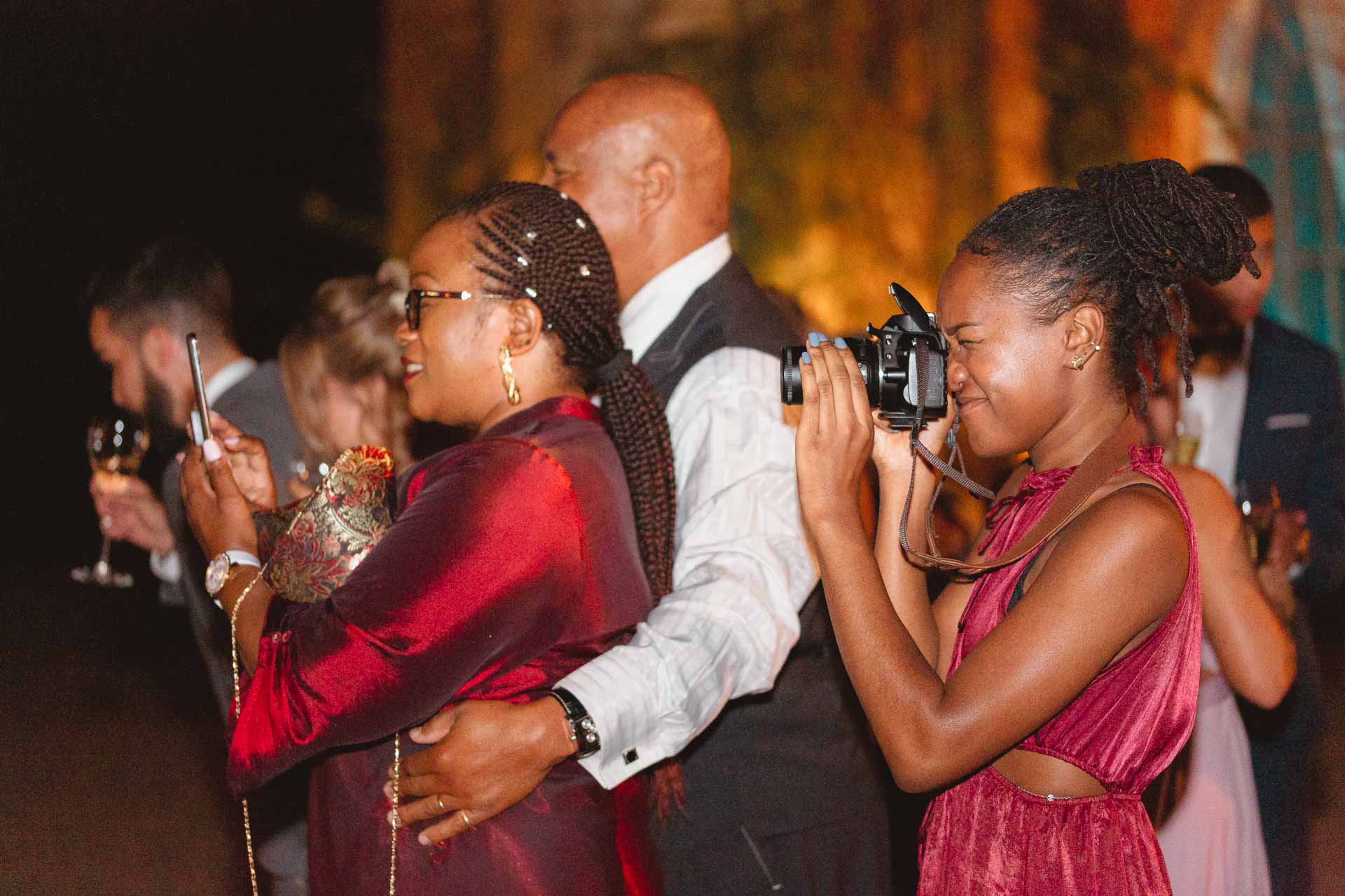 Gli invitati fotografano gli sposi con il telefono e la macchina fotografica
