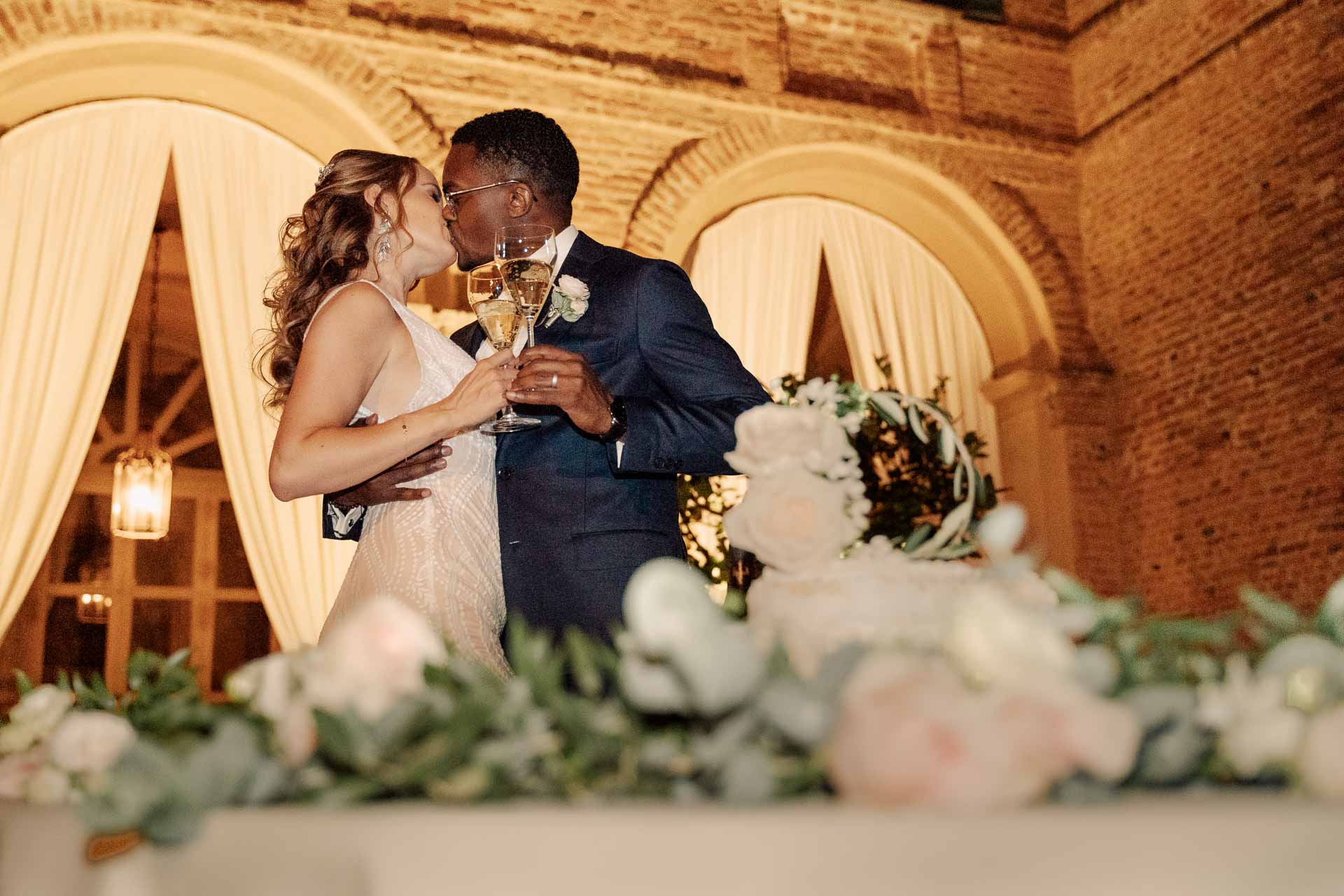 Il bacio degli sposi accanto alla torta