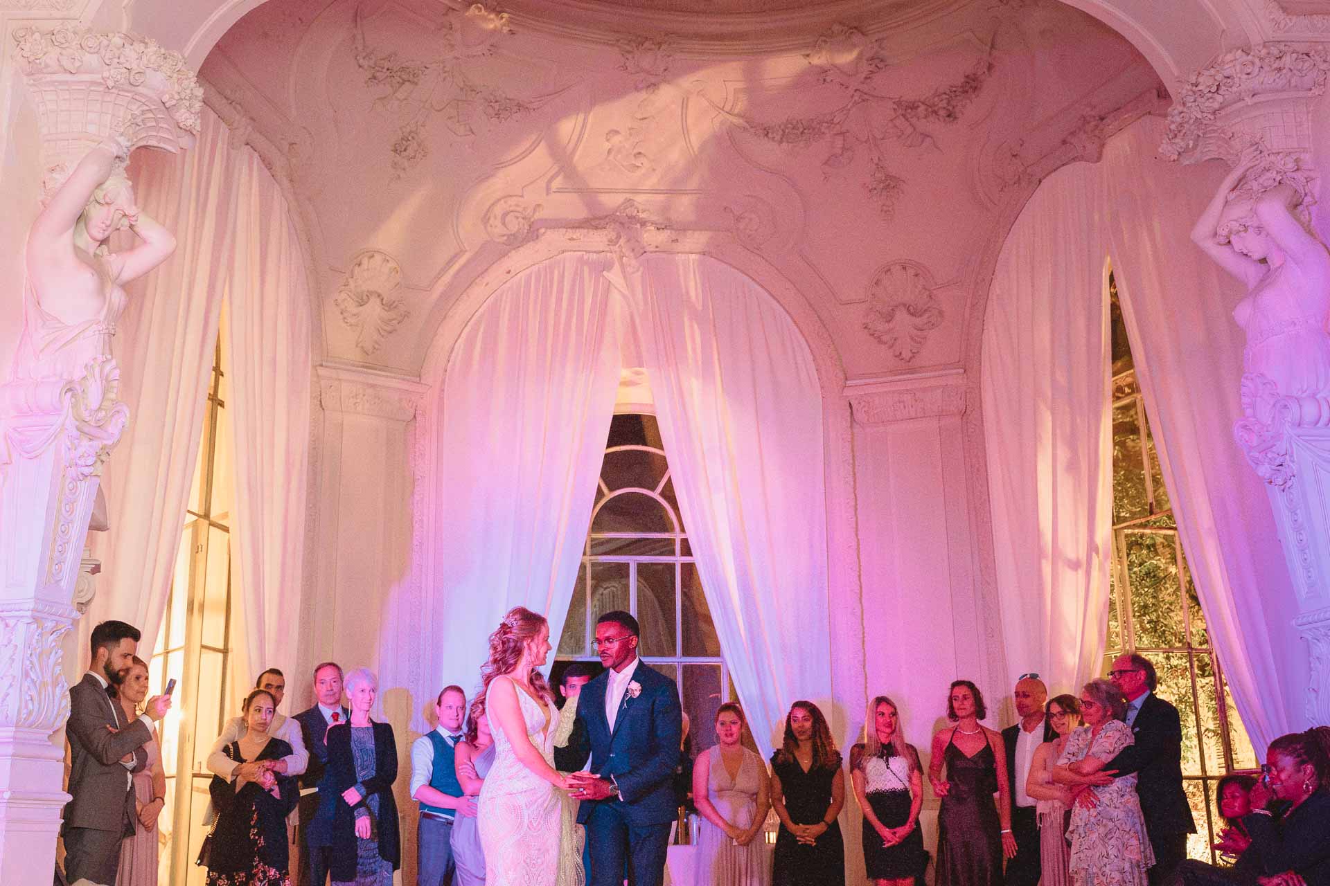 La sala della festa illuminata di rosa, con gli sposi al centro