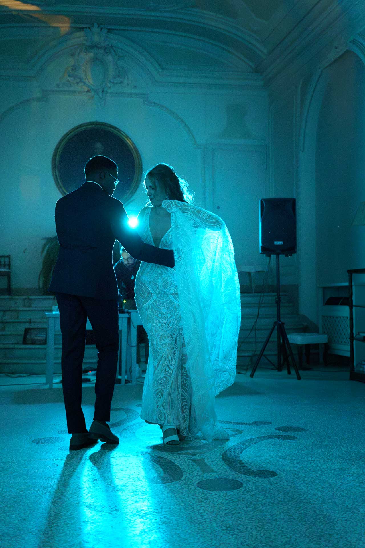 Gli sposi ballano nella luce azzurra della sala