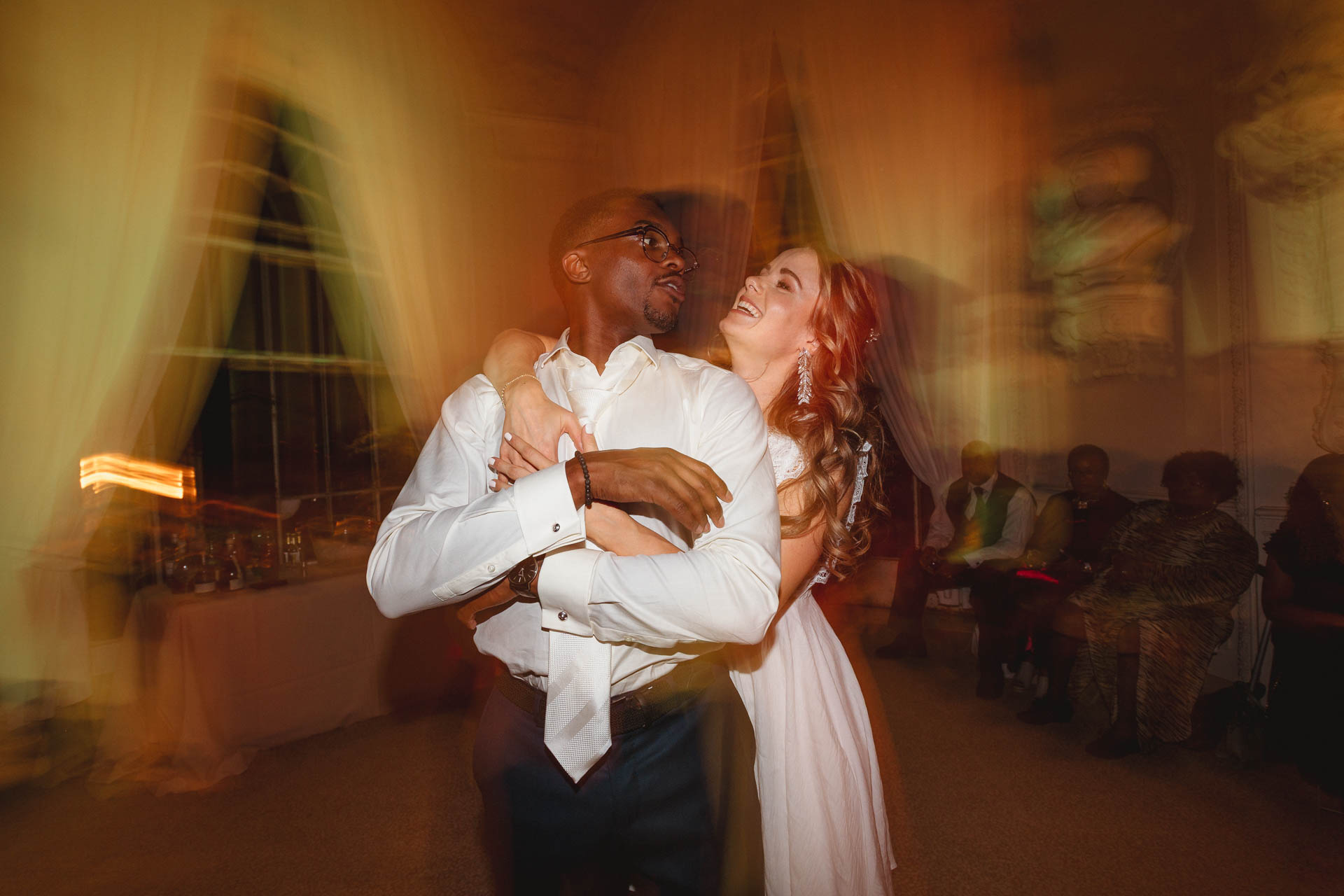 Lo sposo abbraccia la sposa, nelle luci della festa
