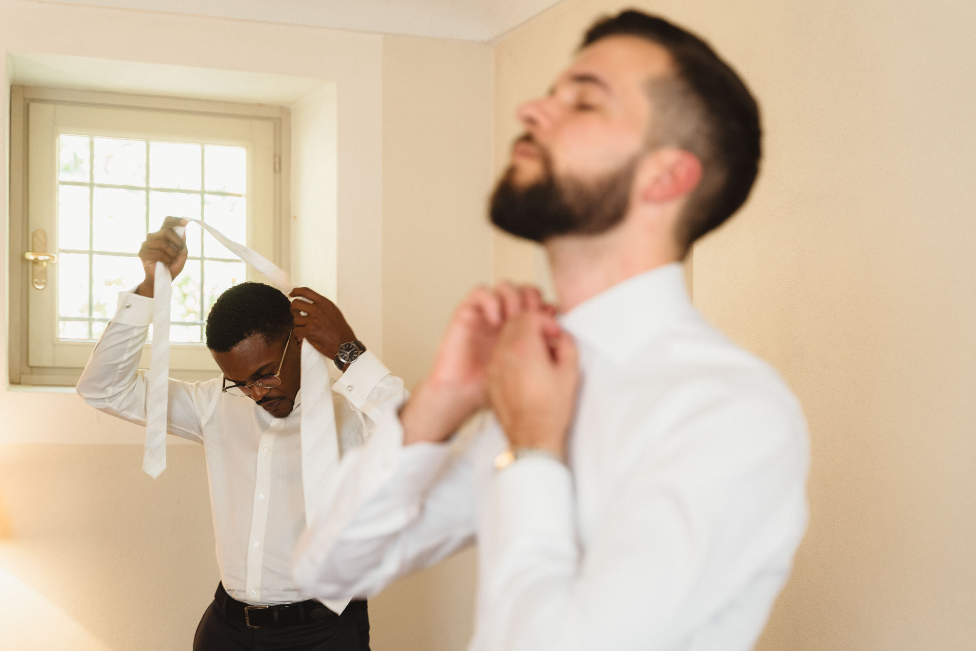 Lo sposo e un amico annodano cravatta e papillon