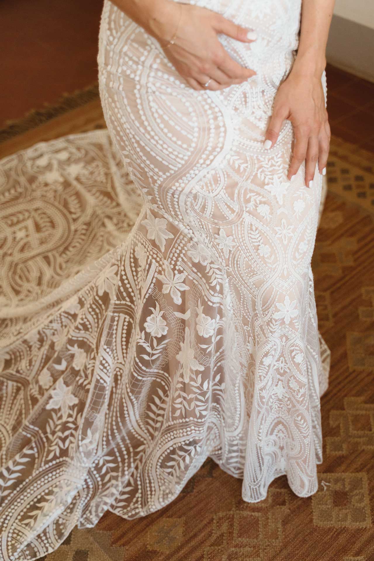 Il pizzo dell'abito sui fianchi della sposa