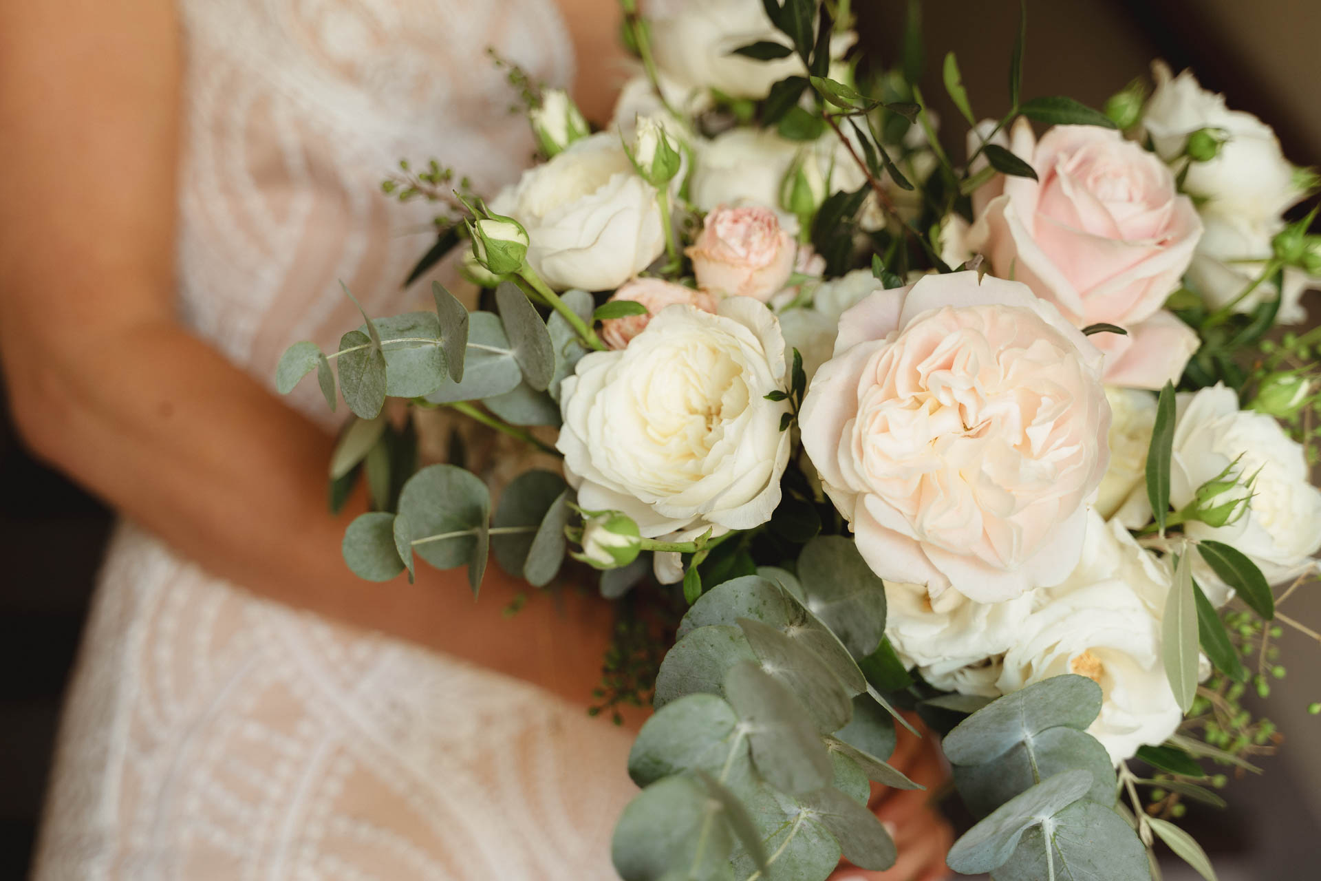 Il bouquet di rose bianche e rosa tra le mani della sposa