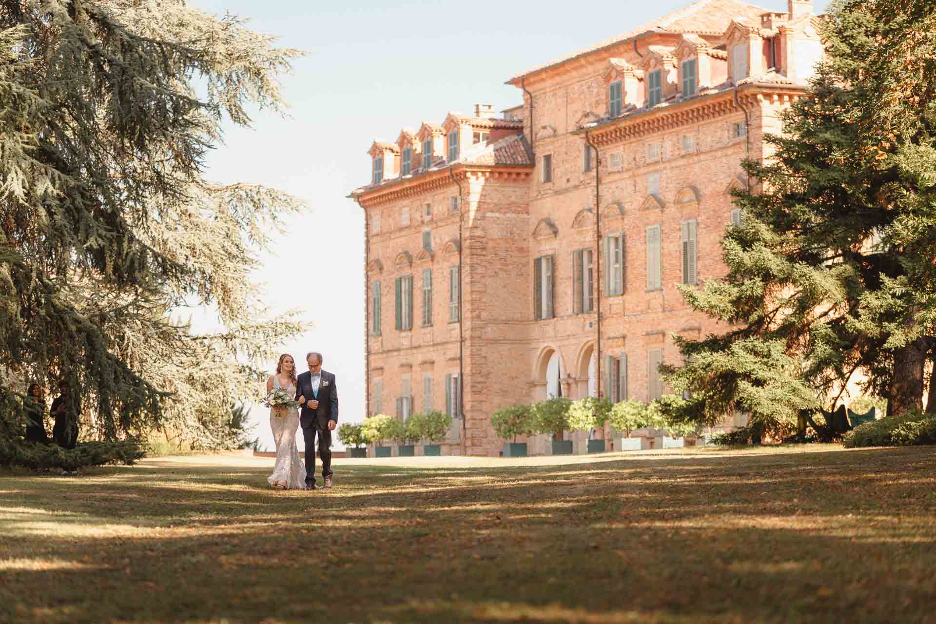 La sposa arriva sul prato davanti al castello della Tenuta Marchesi Alfieri, accompagnata