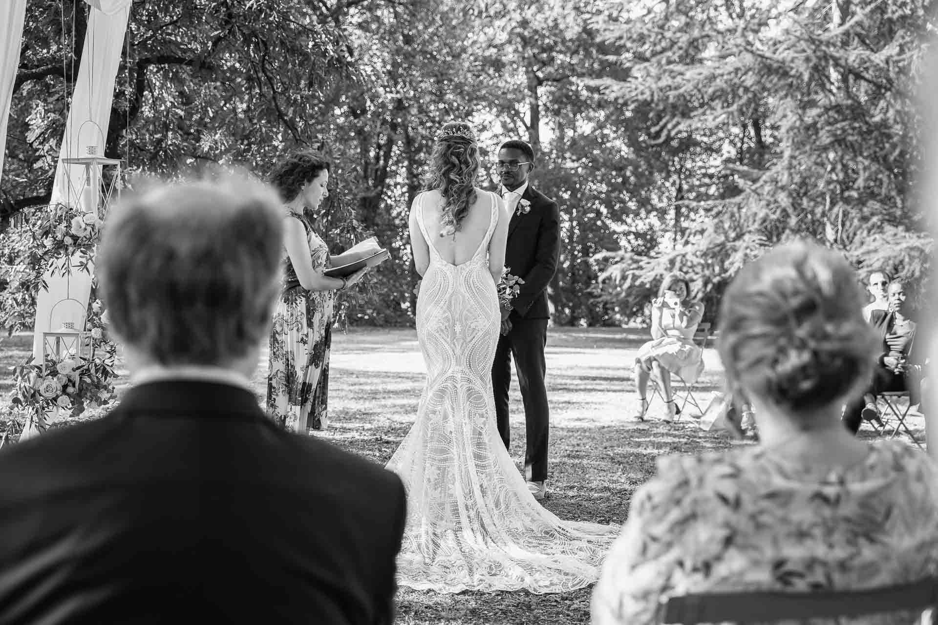 In bianco e nero, gli sposi davanti alla celebrante, visti tra gli invitati