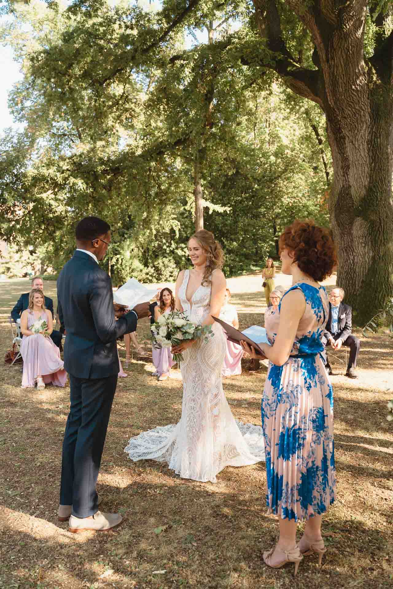 La cerimonia sotto gli alberi, con gli invitati sullo sfondo