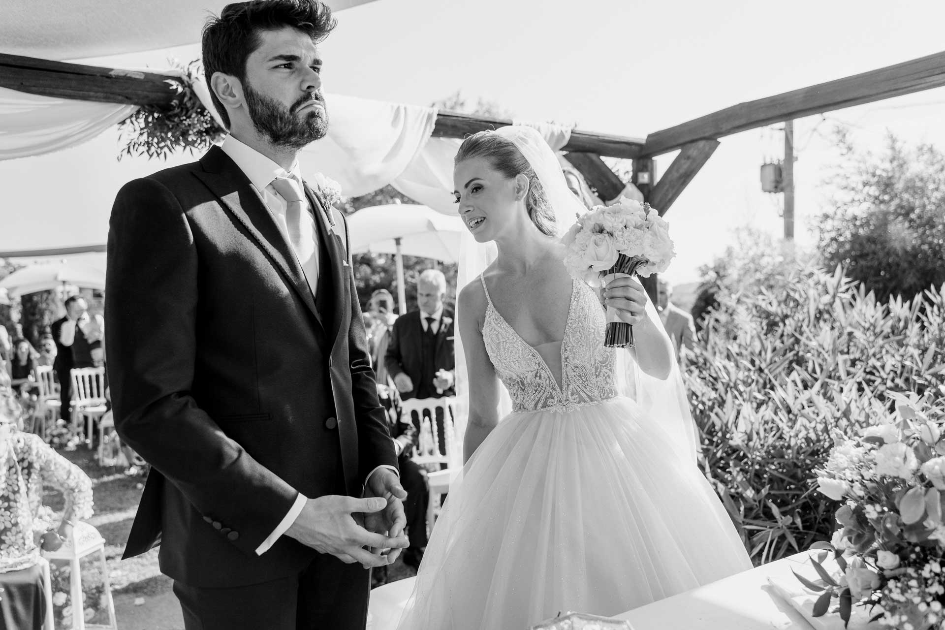 In bianco e nero, lo sposo si volta verso la sposa che arriva