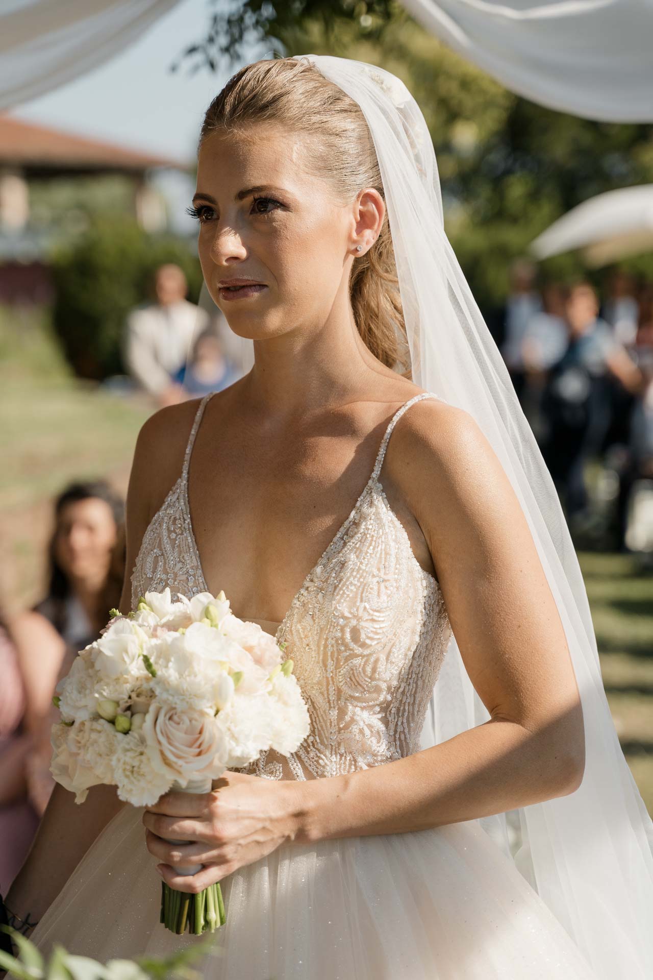 La sposa con il bouquet di rose bianche, gli occhi lucidi
