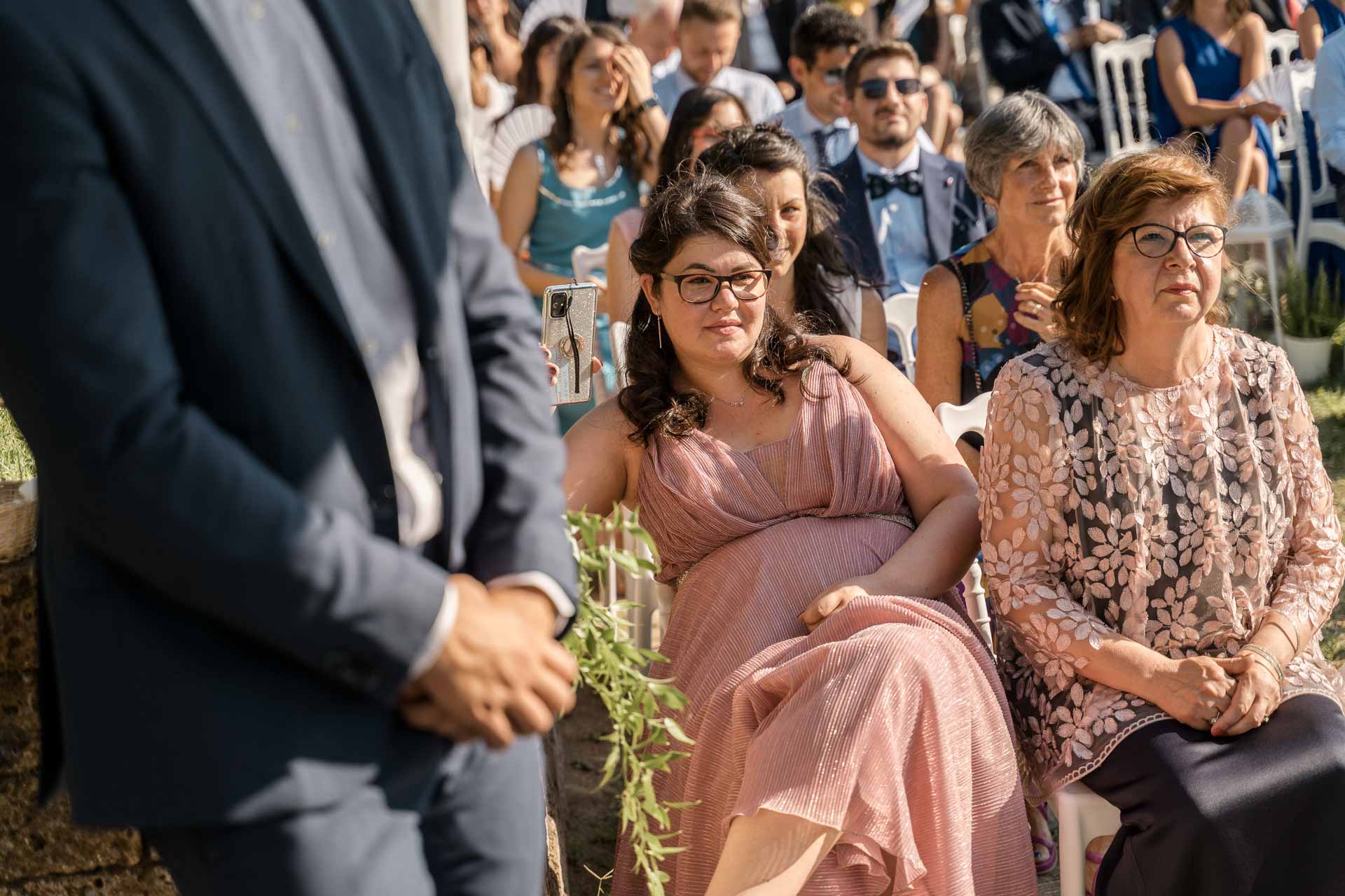 La ragazza in rosa e la mamma dello sposo, sedute in prima fila