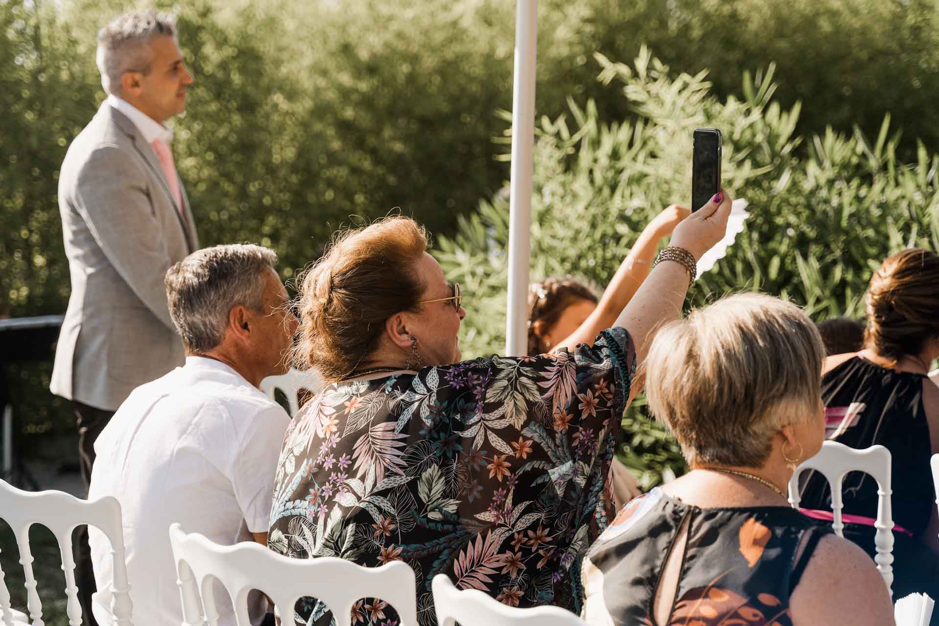 Gli invitati fotografano la cerimonia con il telefono