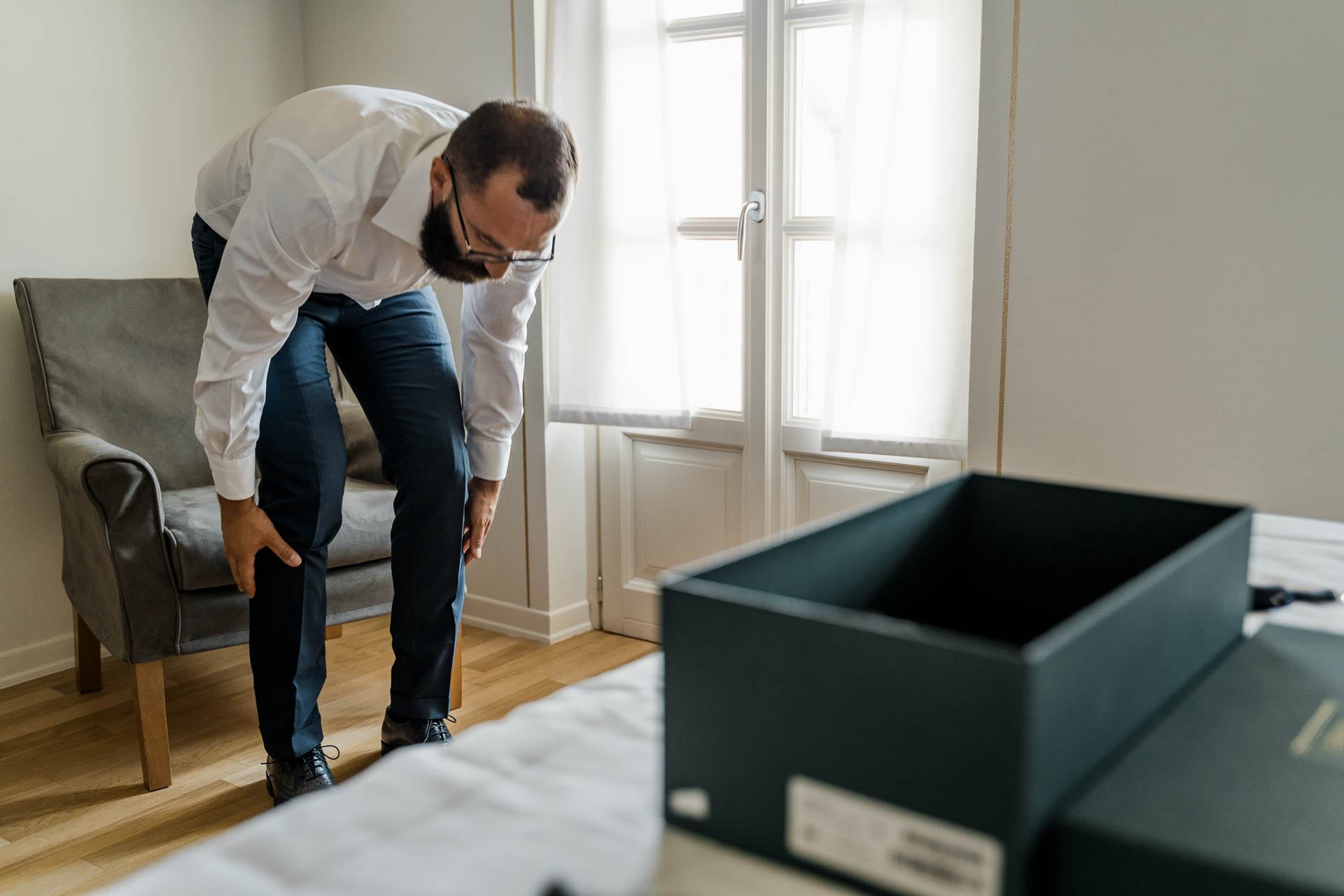L'amico si sistema i pantaloni accanto alla scatola delle scarpe